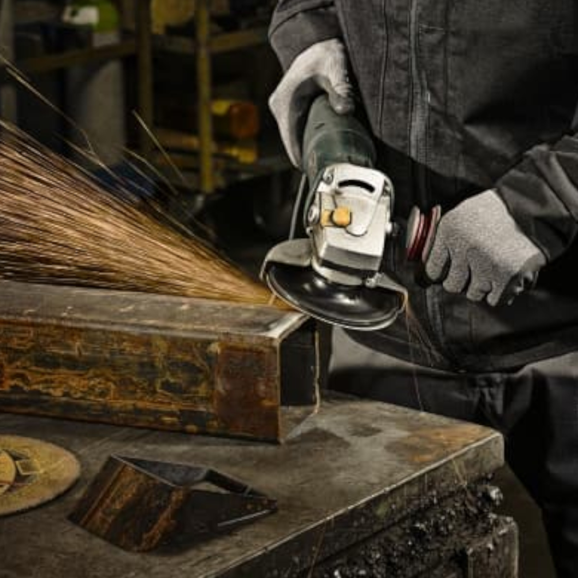 Ein Arbeiter benutzt eine Winkelschleifmaschine, um ein Metallstück zu bearbeiten. Funken sprühen von der Oberfläche. Der Arbeiter trägt Schutzhandschuhe und arbeitet in einer industriellen Umgebung.