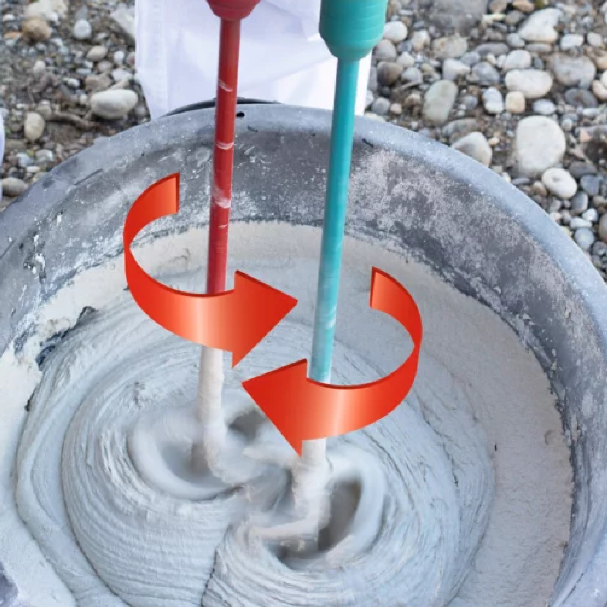 Zwei Mixstäbe, rot und grün, rühren simultan in einem Behälter mit grauem Mörtel. Die Stäbe kreisen in entgegengesetzte Richtungen, was eine gleichmäßige Mischung des Materials zeigt.